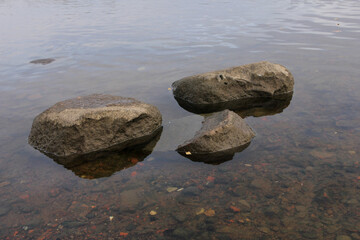 three large gray stones in the water. Zen.