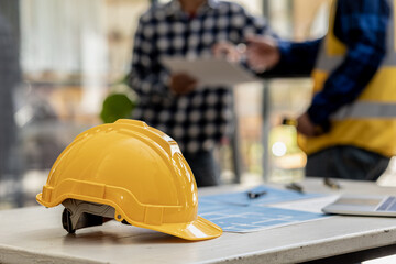 Helmets are used for construction work to ensure safety at work, Architect engineers design houses and interior structures and draw plans through design programs. Architect concept of building design.
