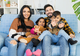 beautiful Hispanic family with children, on the sofa at home
