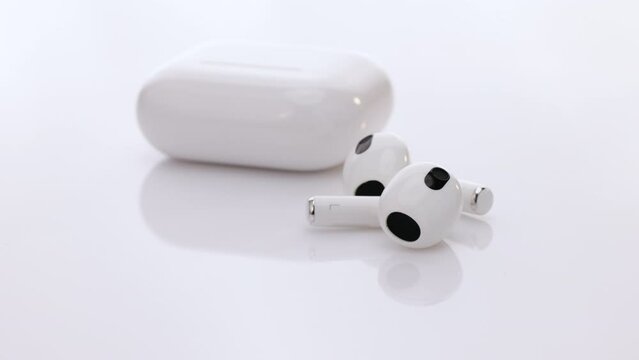 Gadgets and electronic devices. Wireless earphone with noise cancelling technology. Bluetooth headphones isolated on white background. Wireless headphones with charging case.