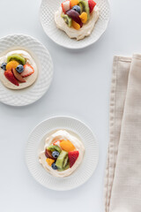 Top down view of fruit topped meringues with copy space in the middle.