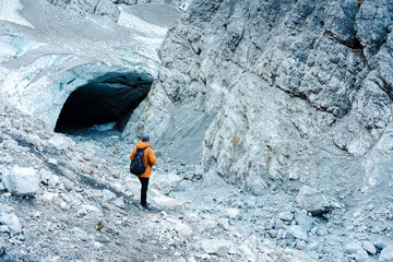 Man standing near entrance of ice cave in Bavarian Alps
