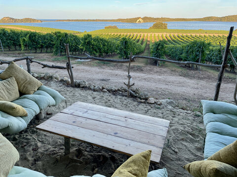 Aleria, Corsica, 5.08.2021. Lounge area at Domaine Terra Vecchia, a Corsican vineyard between sea and mountains. View of Etang de Diana at sunset.