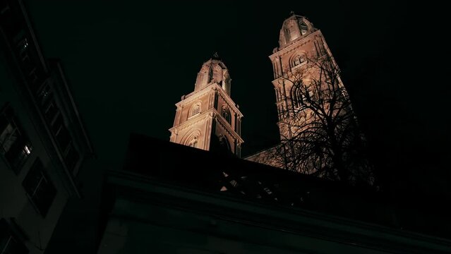 Night architecture of Grossm&uuml;nster Protestant church in the old town in Z&uuml;rich. A Swiss traditional design of the 12th century twin-towered Romanesque cathedral in the nighttime.