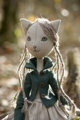  Portrait of a charming doll cat with green eyes dressed in a green jacket looking sideways.