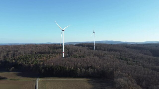 Panoramic view of wind farm or wind park, with high wind turbines for generating electricity