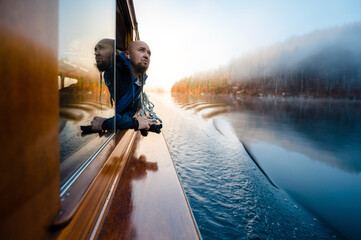 Caucasian man floating on boat on lake Konigsee