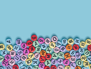 Cyrillic letters colorful buttons on a pastel blue background. Russia, Eastern Europe conceptual backdrop.