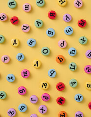 Cyrillic letters colorful buttons on a pastel yellow background. Russia, Eastern Europe minimal concept.
