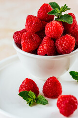 fresh ripe raspberries on a light pink background