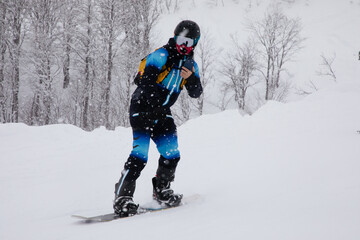 Fototapeta na wymiar Snowboarder riding fast on snow freeride slope.
