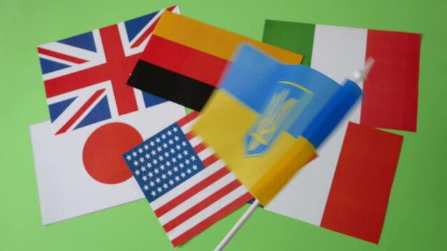 National flags Ukraine waves on G7 flags UK, Germany, Italy, Canada, France, Japan and USA.on green chroma key background, European, UA and Ukraine solidarity and friendship closeup