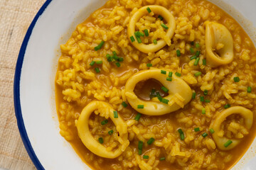 Soupy rice with squid. Spanish paella tapa.