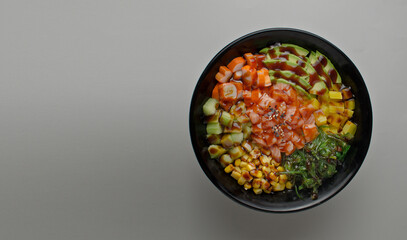 Poke with salmon, avocado, soya, corn, sauce, delicious food. Japanese cuisine. eating with chopstics, top view copy space