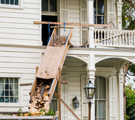 Wooden Chute and Corner of Dumpster Filled with Debris During Demolition of Historic Uptown Home