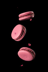 multicolored macaroons in levitation over a dark background