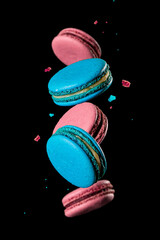 multicolored macaroons in levitation over a dark background