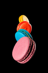 multicolored macaroons in levitation over a dark background