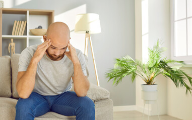 Unwell young man feel frustrated suffer from migraine or headache. Unhealthy male struggle with...