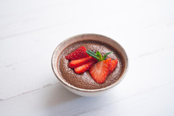 Chocolate mousse with pieces of fresh strawberry.