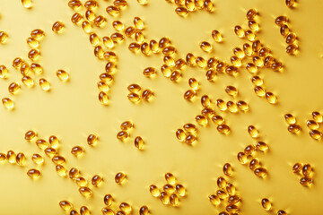 Capsules in a shell with liquid vitamin D3 on a yellow background and a place for text