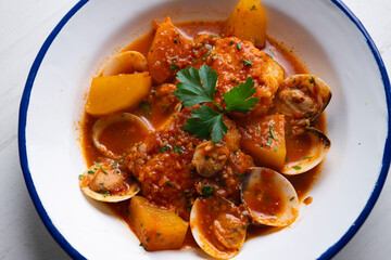 Cod with potatoes and clams. Traditional recipe from the north of Spain.