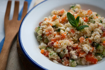 Fake couscous made with crushed cauliflower, green pepper and other vegetables. vegan recipe.