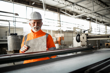 Successful ceramic tile production and factory worker doing quality control.