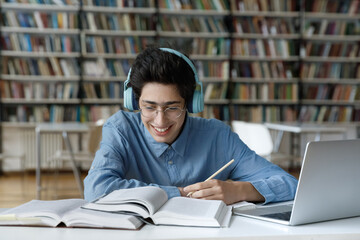 Happy motivated millennial Jewish male student in glasses favorite music in headphones, feeling...