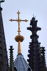 Fototapeta na wymiar Golden cross on the roof of the Cologne Cathedral against the sky