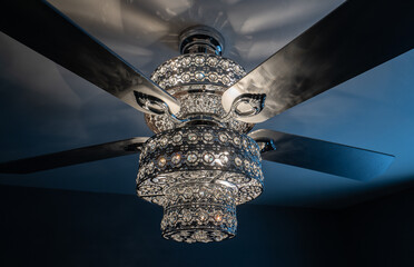 ornate ceiling fan with four blades hangs over head