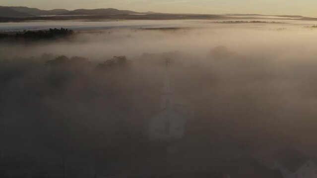 Spectacular aerial church surrounded by dense fog Landscape shot