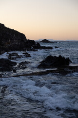 Fototapeta na wymiar Coucher de soleil sur les vagues se fracassant sur les rochers au pied de Collioure (Occitanie, France)