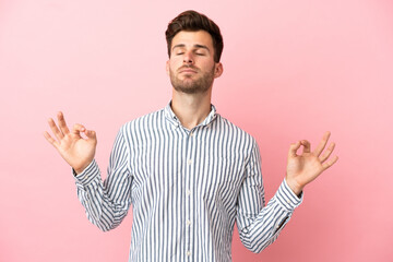 Young caucasian handsome man isolated on pink background in zen pose