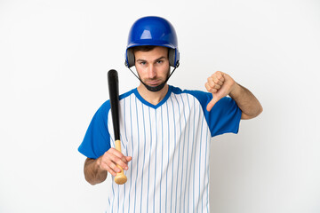 Young caucasian man playing baseball isolated on white background showing thumb down with negative expression