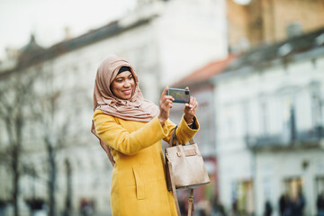 Black Muslim Woman With Hijab Taking Photos By Smart Phone On The Street
