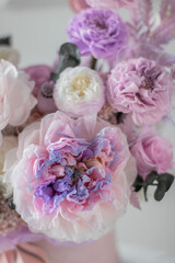 Obraz premium Beautiful box with peonies and roses in a pink box on grey background coffee table. Bouquet of tenders peonies a girl for mother's day, valentine's day, Woman's day 8 march.