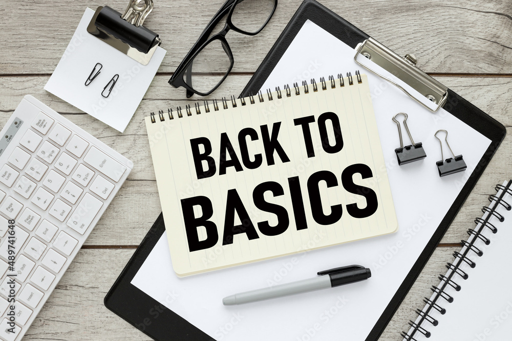 Poster back to basics, notepad with text on a wooden table and a folder with a clip. keyboard . working tab