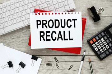 Product Recall. text on a sheet of paper on a red notepad on a wooden background