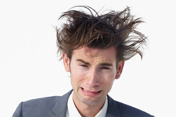 I need help. A young businessman with messy hair whimpering while isolated on white.