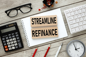 streamline refinance. text in notepad on wooden blocks with white keyboard calculator. wooden background. flat laying.