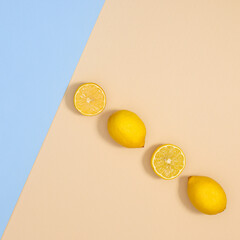Summer composition of fresh lemons on pastel beige and blue background. FLat lay tropic concept. Creative copy space