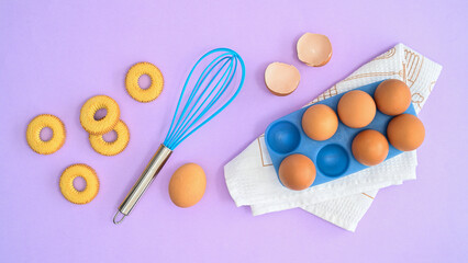 Making cookies ingredients and supplies on pastel purple background. Creative food layout