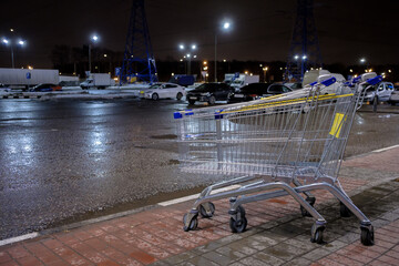 Empty blue and yellow shopping baskets next to a shop at night. Selective focus. Humanitarian catastrophe and lack of food in the Ukrainian store during the war. No war.