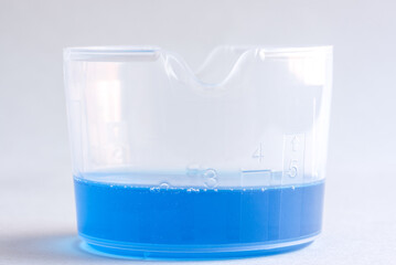 Liquid Laundry Detergent in a Measuring Cup - 489742819