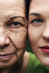 Close face of grandmother and granddaughter. They look at the camera.