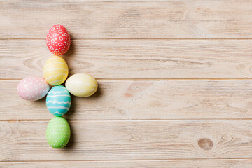 Obraz na płótnie Canvas holiday preparation Multi colors Easter eggs on colored background, cross show the religious and secular side of Easter. Pastel color Easter eggs. holiday concept with copy space