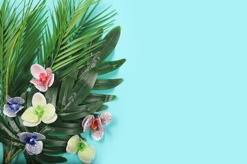 Fototapeta premium Summer composition, exotic abstract background with tropical palm leaves and orchids on sunny table, summer holiday concept, banner, flat lay, space for text, selective focus