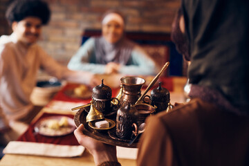 Close-up of Middle Eastern woman serving traditional Turkish coffee at home