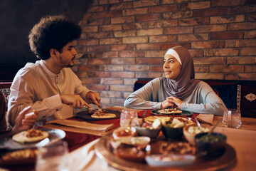 Fototapeta na wymiar Young Muslim couple talk while having meal on Iftar during Ramadan.